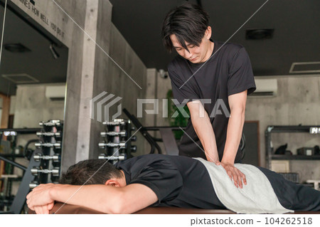 一名男子正在接受運動手法治療，一名醫療教練/柔道治療師（下背部） 104262518