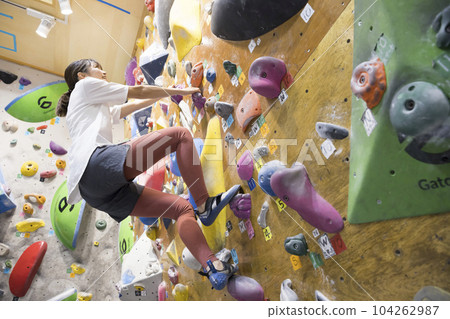 Young woman bouldering 104262987