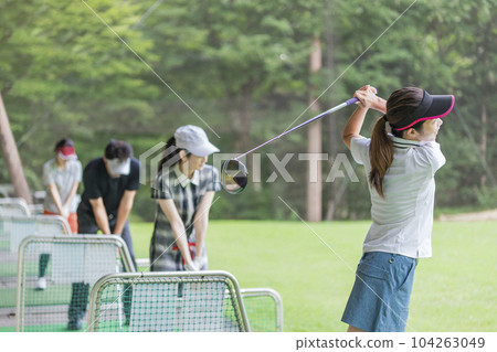 Golf driving range, hitting, golf player practicing swing at golf center, men and women of golfers 104263049