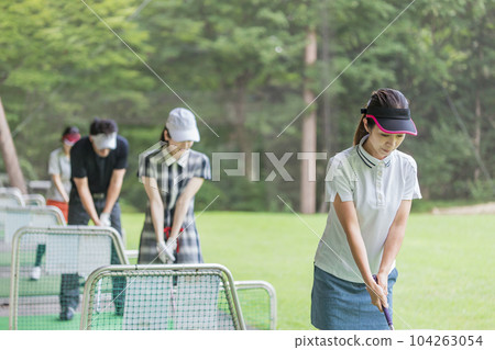 Golf driving range, hitting, golf player practicing swing at golf center, men and women of golfers Golf driving range, hitting, golf player practicing swing at golf center, men and women of golfers 104263054