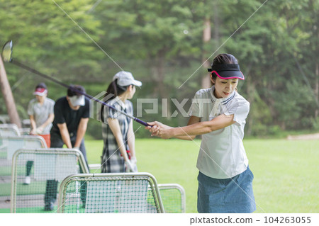 Golf driving range, hitting, golf player practicing swing at golf center, men and women of golfers Golf driving range, hitting, golf player practicing swing at golf center, men and women of golfers 104263055