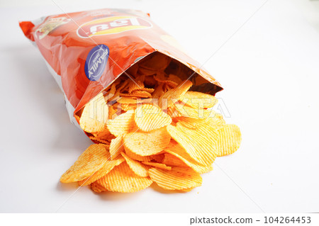 Bangkok, Thailand - May 15, 2022 Potato chips in open bag, delicious BBQ seasoning spicy for crips, thin slice deep fried snack fast food. Bangkok, Thailand - May 15, 2022 Potato chips in open bag, delicious BBQ seasoning spicy for crips, thin slice deep fried snack fast food. 104264453