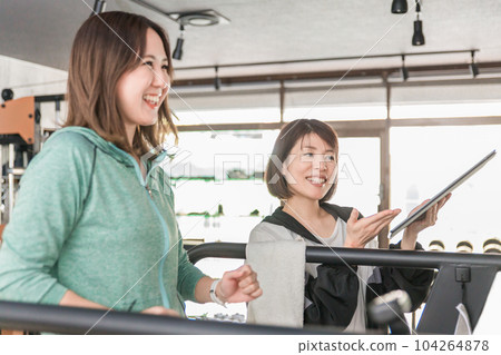 指導女性在跑步機上跑步和慢跑的私人教練和飲食教練 指導女性在跑步機上跑步和慢跑的私人教練和飲食教練 104264878