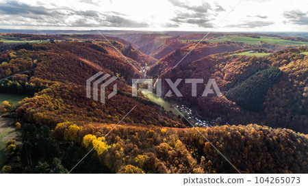 fall autumn aerial view rock with medieval castle Ehrenburg on it near moselle river in Brodenbach with forest hills 104265073