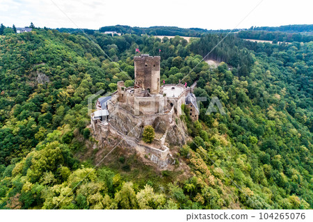 aerial view rock with medieval castle Ehrenburg on it near moselle river in Brodenbach with forest hills 104265076