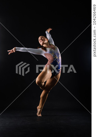 Full length portrait of plump woman doing physical exercise, jumping, white and black background. 104266469