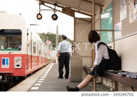 High school girl waiting for the train at the station platform High school girl waiting for the train at the station platform 104266702