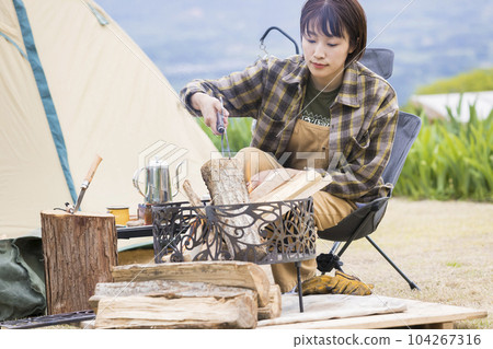 A young woman using fire scissors to watch the bonfire day, bonfire, outdoor, solo camp A young woman using fire scissors to watch the bonfire day, bonfire, outdoor, solo camp 104267316