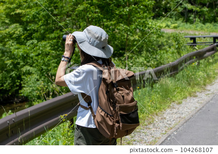 A woman bird-watching on the promenade along Lake Nozori 104268107