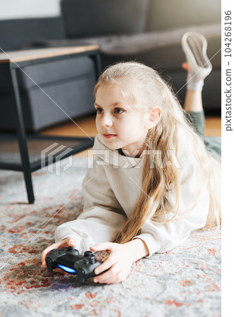 Girl playing video game at home 104268196