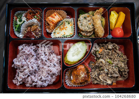 A lunch box containing rice, meat, fish, vegetables, kimchi, tempura, fruit, etc. 104268680