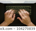 Hands speedtyping on a backlit keyboard 104270839