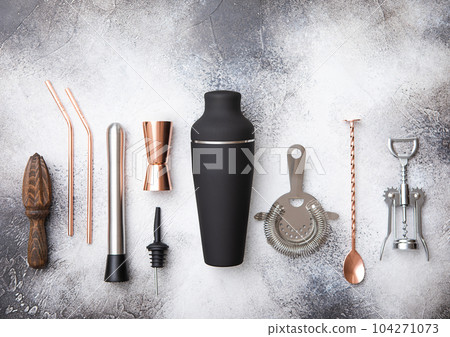 Copper and stainless steel shaker,pourer,spoon,strainer,muddler and wine opener on light board. Copper and stainless steel shaker,pourer,spoon,strainer,muddler and wine opener on light board. 104271073
