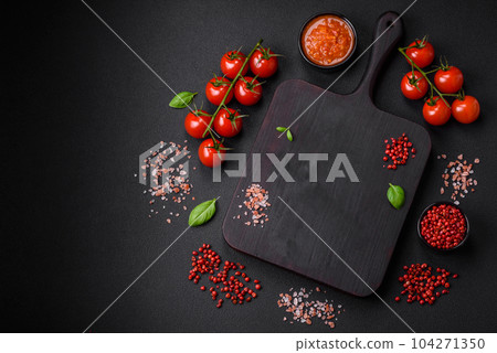Raw black spaghetti pasta with tomatoes, salt, spices and herbs 104271350