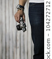 Right hand holding camera with watch and bracelet 104272712