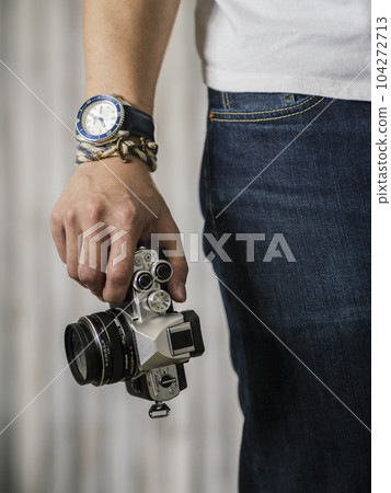 Right hand holding camera with watch and bracelet Right hand holding camera with watch and bracelet 104272713