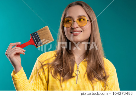Young woman artist with brush on blue background. Creative person, fantasy, idea 104273493