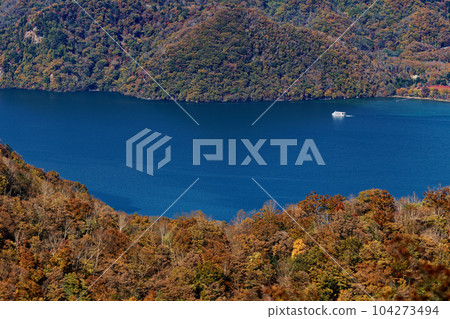 Autumn leaves of Lake Chuzenji and a pleasure boat seen from the Oku-Nikko Shayama ridgeline 104273494