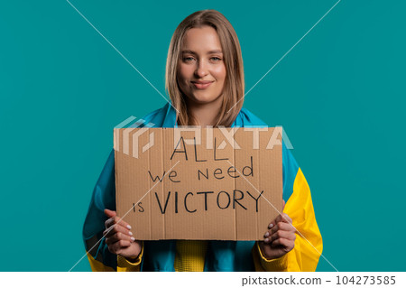 Ukrainian woman with cardboard All we need is victory on blue background.  104273585