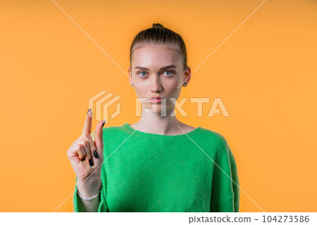 Young woman showing small invisible abstract subject, tiny object sizes. Yellow Young woman showing small invisible abstract subject, tiny object sizes. Yellow 104273586