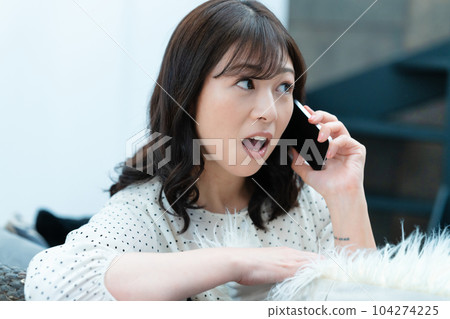一位中年婦女在客廳用智能手機說話 104274225