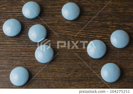 Heap of blue pills capsule on wooden table Heap of blue pills capsule on wooden table 104275251