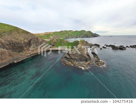 Aerial photograph of the emerald blue cove at Sumikai Cape on Rebun Island. Aerial photograph of the emerald blue cove at Sumikai Cape on Rebun Island. 104275416
