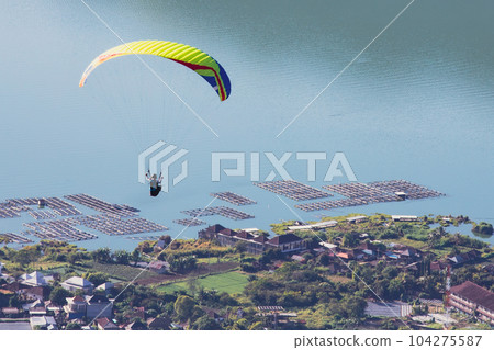Paraglider flies in front of the ocean Paraglider flies in front of the ocean 104275587