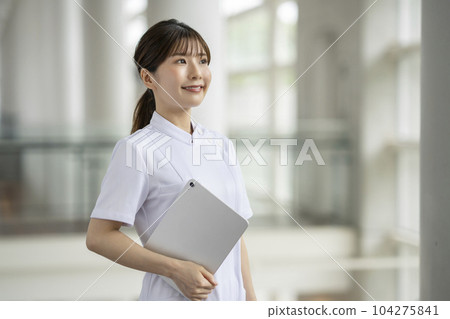Smiling woman in white with a tablet Portrait 104275841