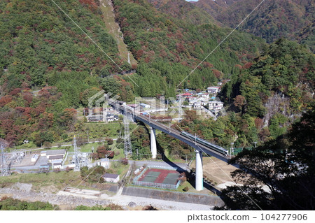 A train running on the Yunishigawa Bridge on the Aizu Kinugawa Line during the fall foliage season 104277906