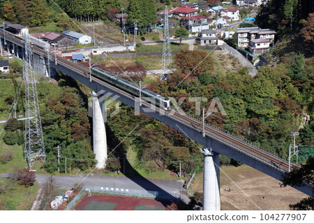 A train running on the Yunishigawa Bridge on the Aizu Kinugawa Line during the fall foliage season 104277907