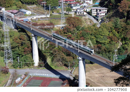 A train running on the Yunishigawa Bridge on the Aizu Kinugawa Line during the fall foliage season 104277908