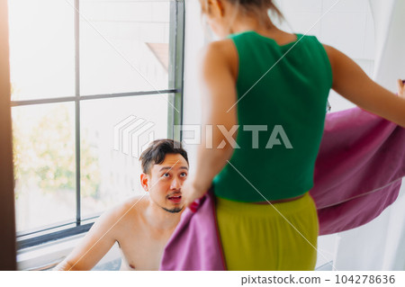 Happy childish disable man being take care of showering by his wife. 104278636
