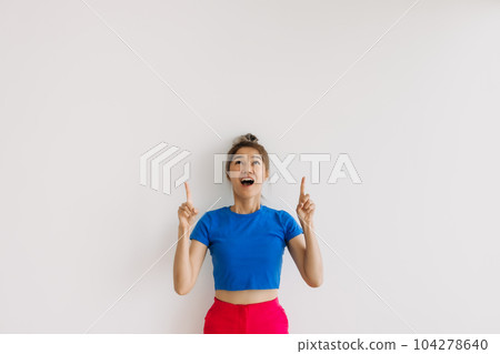 Shocked and surprised woman looking up at empty space isolated on white. 104278640