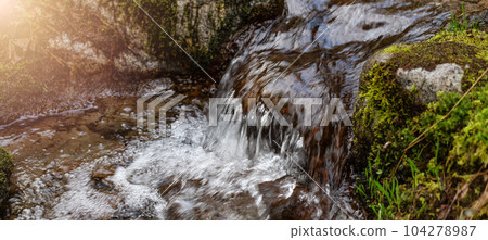 Fresh Water running down the River Stream around the smooth rocks. 104278987