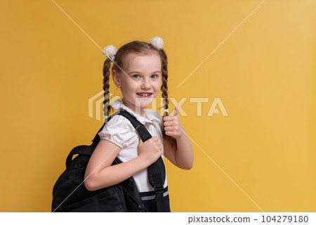 A cheerful girl is ready to go back to school, education and teaching children. High quality photo 104279180