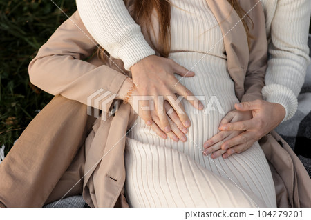Family day. Stylish unrecognisable marriage pregnant couple waiting for baby. Man is hugging and touching woman belly outdoors. World IVF Day. Pregnancy, parenthood, motherhood, love, family concept. Family day. Stylish unrecognisable marriage pregnant couple waiting for baby. Man is hugging and touching woman belly outdoors. World IVF Day. Pregnancy, parenthood, motherhood, love, family concept. 104279201