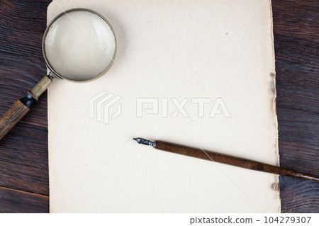 Antique vintage magnifying glass with old paper and ink feather pen Antique vintage magnifying glass with old paper and ink feather pen 104279307