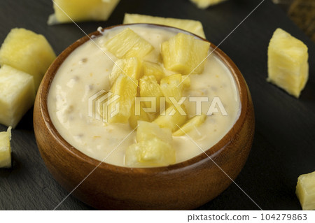 milk pineapple yogurt with pieces of pineapple and other fruits 104279863