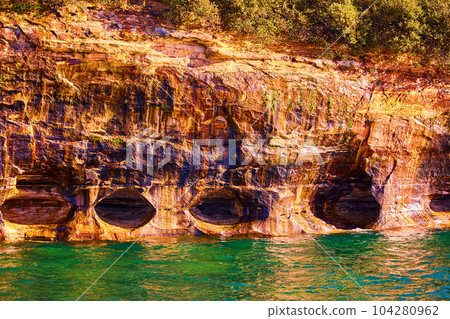 Turquoise water and ominous caves and hollow cliff side cavers Pictured Rocks 104280962