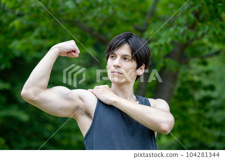 Foreign man doing muscle training in a fresh green park Foreign man doing muscle training in a fresh green park 104281344