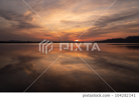 Morning sun reflecting on the surface of the lake Morning sun reflecting on the surface of the lake 104282141