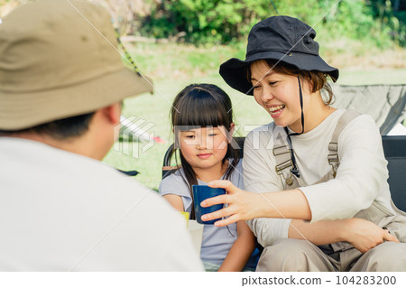Family toasting with juice at the campsite (outdoor, travel, leisure, picnic) 104283200