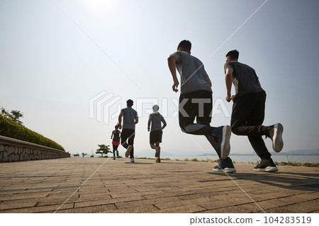 group of young asian adult men and woman running outdoors, rear and low angle view 104283519