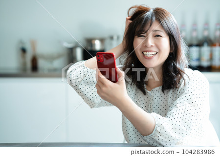 一位中年婦女驚訝地看到智能手機 104283986