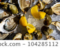 Fresh oysters and whelk platter with lemon on the ice. 104285112