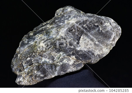 Plagioclase (feldspar) - unworked rock specimen on dark background Plagioclase (feldspar) - unworked rock specimen on dark background 104285285