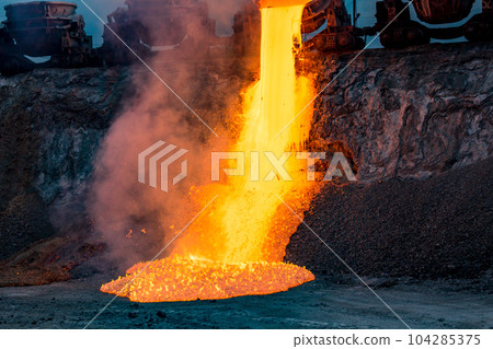 Colorful stream of molten metal at a steel mill. Blast furnace slag at the iron foundry Colorful stream of molten metal at a steel mill. Blast furnace slag at the iron foundry 104285375