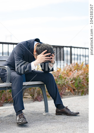 Worried businessman bench 104288167