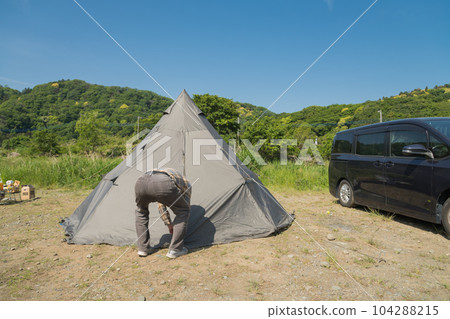 [在中津川的河床上打開汽車露營帳篷入口的中間露營者] 104288215